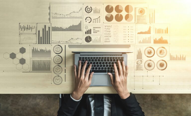 Desk with keyboard, financial charts and investment reports, illustrating a private markets fund launch and asset management.