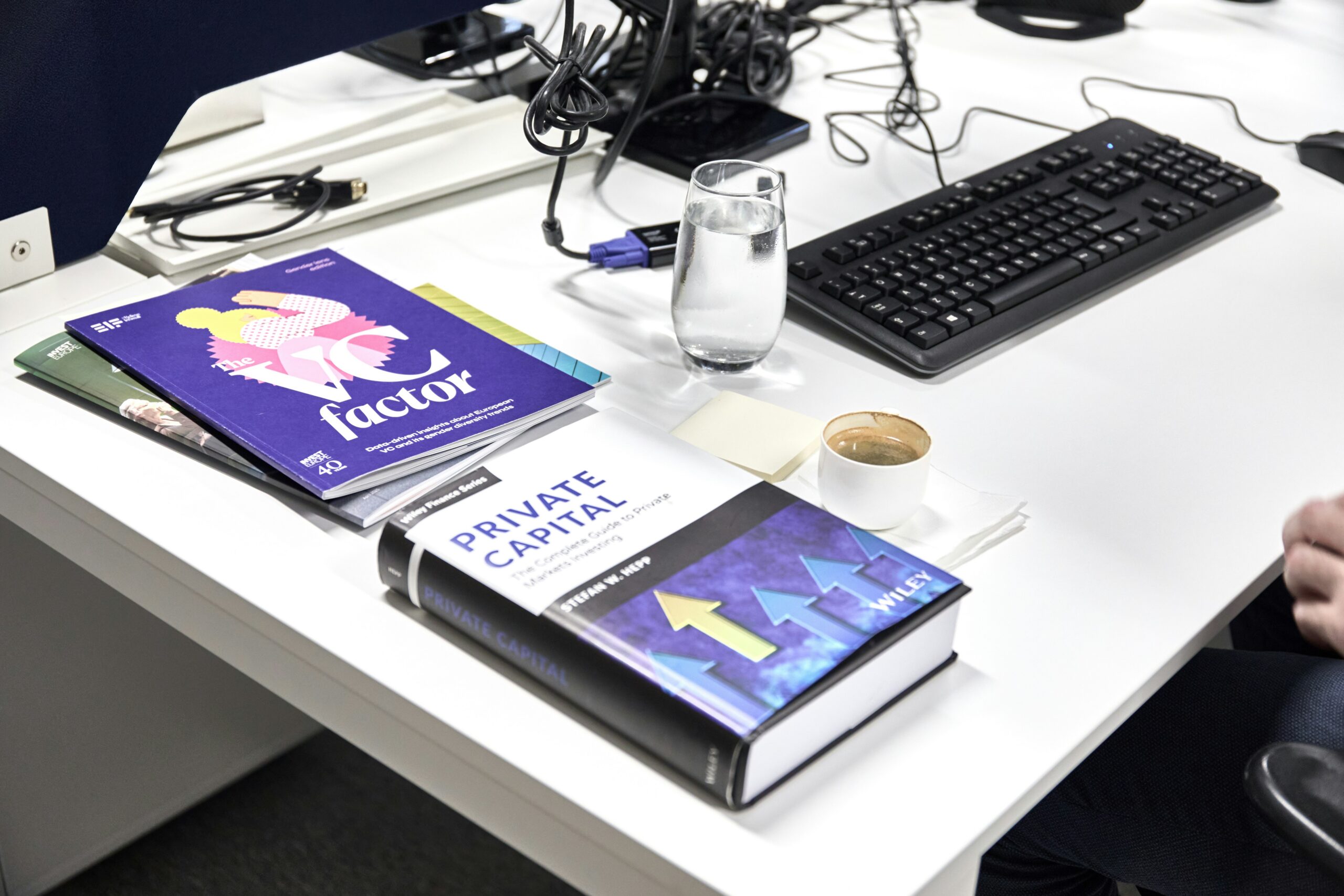 Book titled "Private Markets" on a desk beside a laptop and office workspace, illustrating alternative investments and asset management.